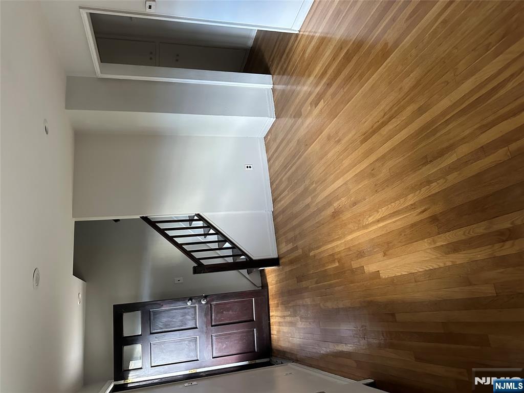743 Newcomb Road Ridgewood, NJ 07450 - Photo 3 of 16 a view of an empty room with wooden floor and stairs