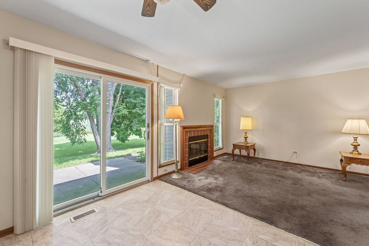 1228 Coldspring Road Elgin, IL 60120 - Photo 11 of 30 a view of a livingroom with a fireplace a ceiling fan and a window