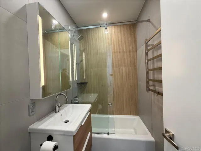 a bathroom with a tub a sink and mirror