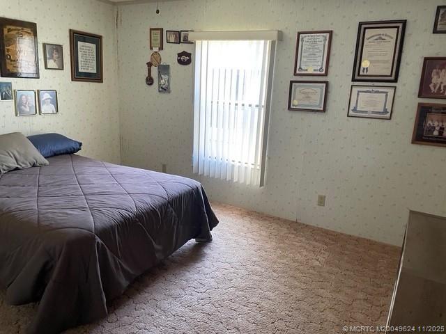 2883 Southwest Monarch Trail Stuart, FL 34997 - Photo 15 of 17 a bedroom with a bed a painting on the wall and a window