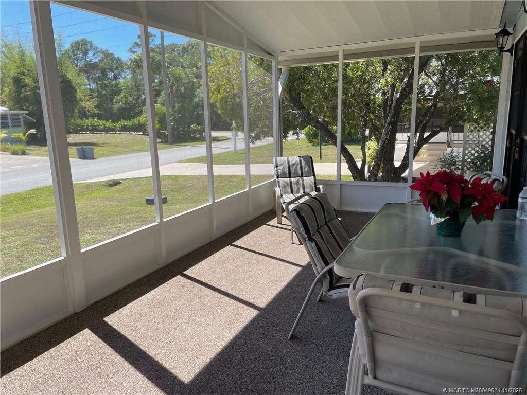 2883 Southwest Monarch Trail Stuart, FL 34997 - Photo 5 of 17 a living room with a floor to ceiling window and a potted plant