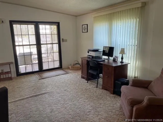 a view of a livingroom with workspace and a window