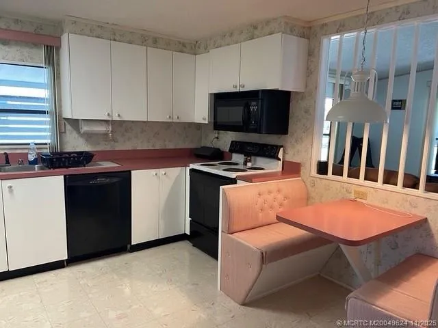 a kitchen with stainless steel appliances a stove a sink a microwave a refrigerator and cabinets