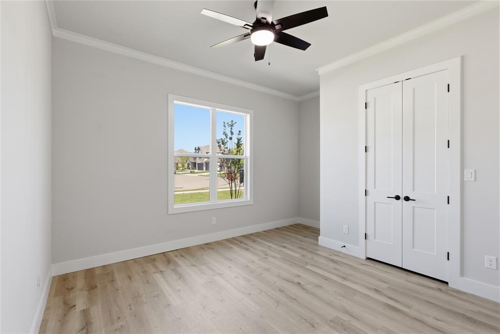713 Anne Road Van Alstyne, TX 75495 - Photo 16 of 29 Bright room featuring wood-finish flooring, a contemporary ceiling fan, and a large window with white trim