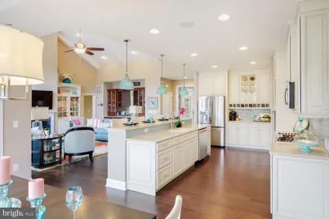 a large kitchen with stainless steel appliances kitchen island granite countertop a refrigerator and a stove top oven