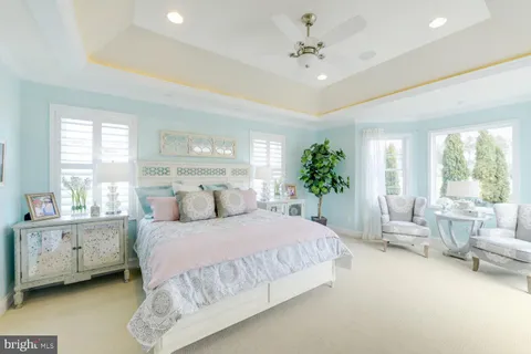 a bedroom with a large bed and windows