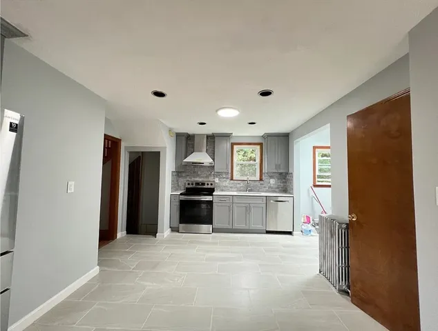 a large kitchen with a stove a refrigerator and a sink