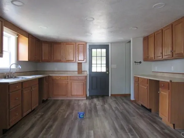 a kitchen with sink cabinets and wooden floor