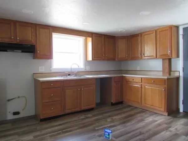 a kitchen with granite countertop wooden cabinets a sink and dishwasher
