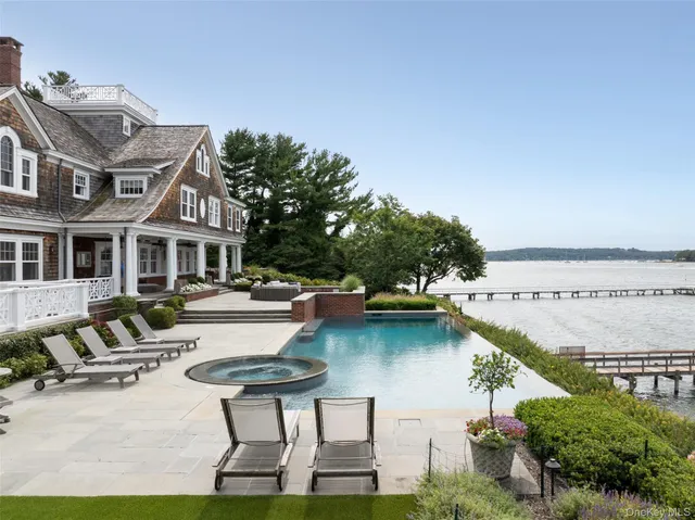 a swimming pool with outdoor seating and lake view