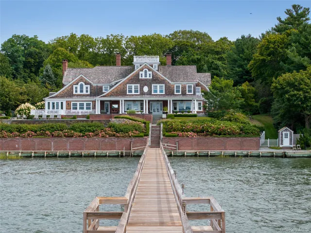 a front view of a house with a yard and potted plants