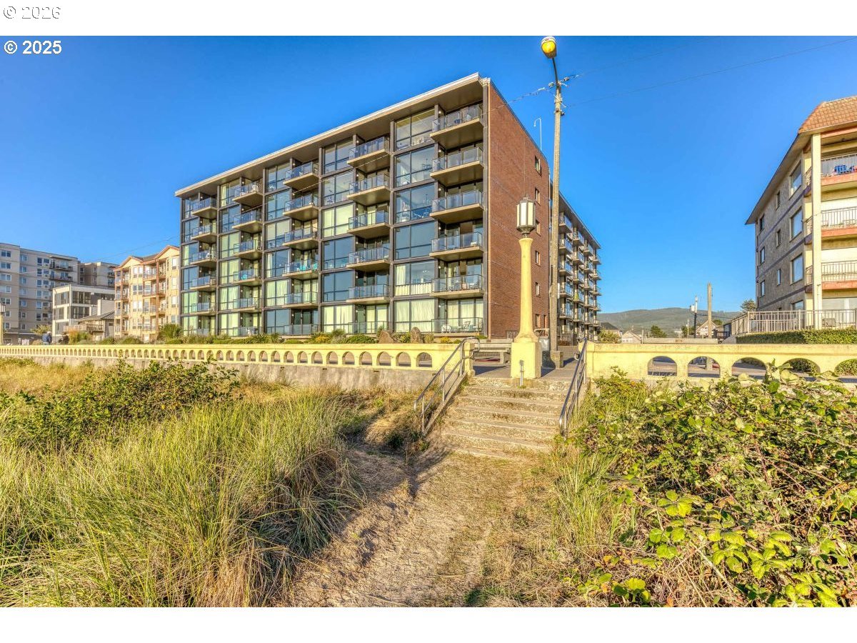 475 South Promenade, Unit 518 Seaside, OR 97138 - Photo 1 of 29 a view of swimming pool with a building in the background
