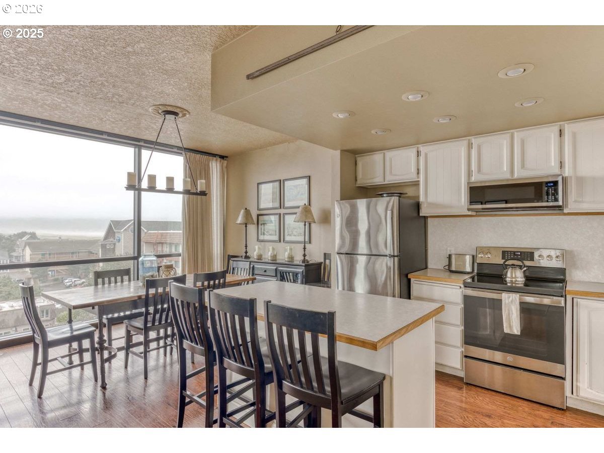 475 South Promenade, Unit 518 Seaside, OR 97138 - Photo 13 of 29 a kitchen with stainless steel appliances granite countertop a stove a refrigerator a kitchen island a stove and a refrigerator