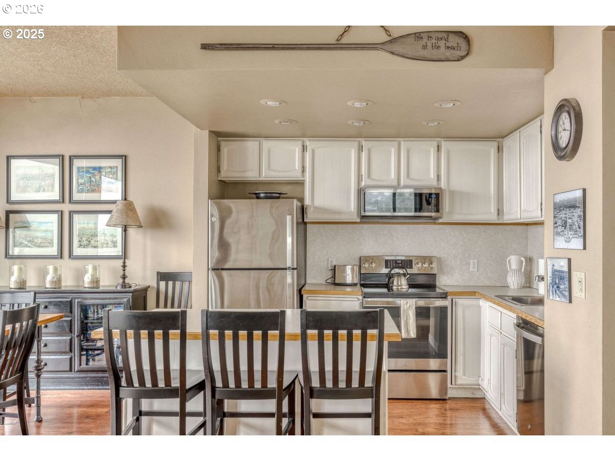 475 South Promenade, Unit 518 Seaside, OR 97138 - Photo 14 of 29 a kitchen with stainless steel appliances kitchen island granite countertop a stove a sink a dining table and chairs
