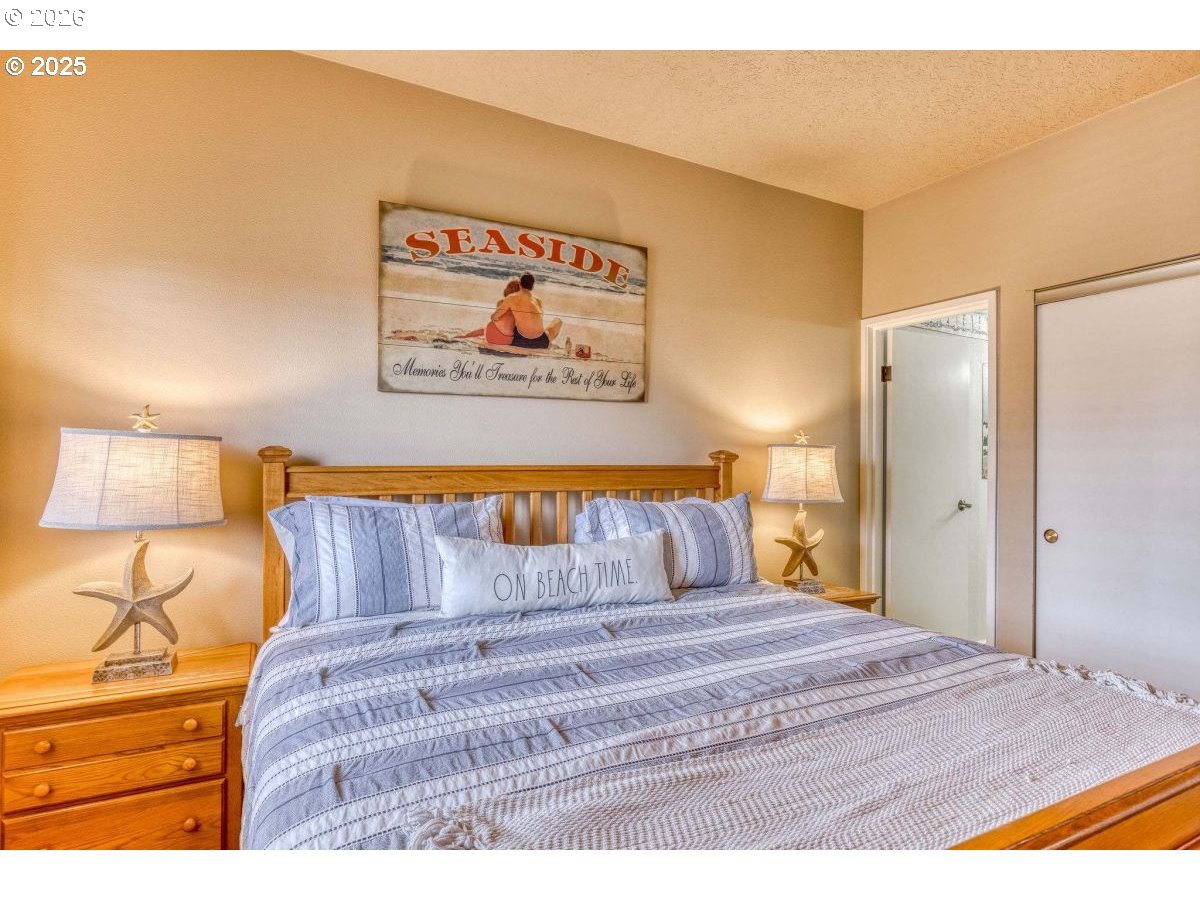 475 South Promenade, Unit 518 Seaside, OR 97138 - Photo 17 of 29 a bedroom with a bed and a painting on the wall