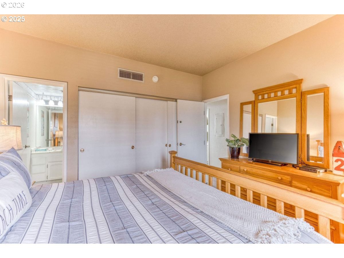 475 South Promenade, Unit 518 Seaside, OR 97138 - Photo 18 of 29 a bedroom with a bed and a flat screen tv