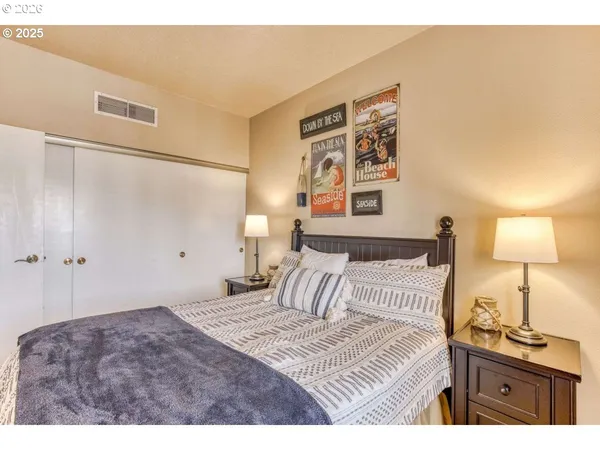 a bedroom with a bed and a lamp on dresser