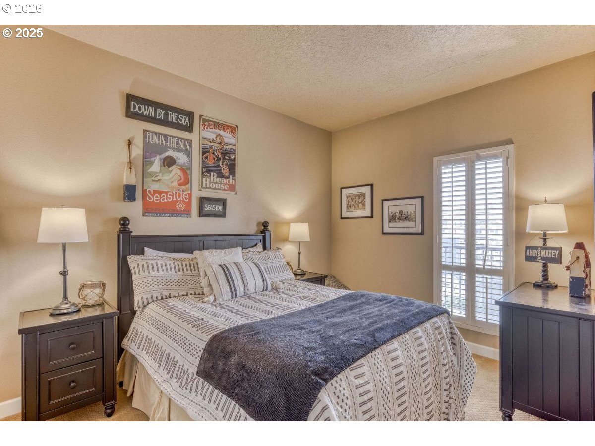 475 South Promenade, Unit 518 Seaside, OR 97138 - Photo 21 of 29 a bedroom with a bed and a lamp on dresser