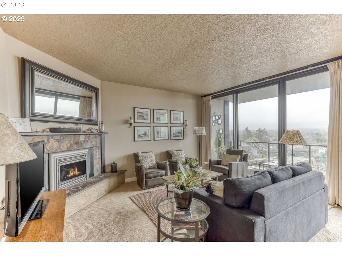 475 South Promenade, Unit 518 Seaside, OR 97138 - Photo 3 of 29 a living room with furniture a fireplace and a large window