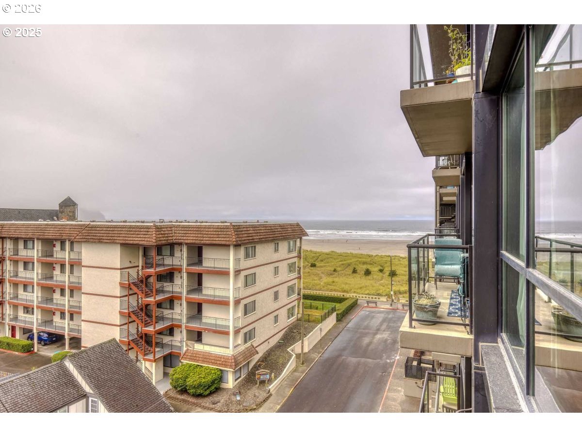 475 South Promenade, Unit 518 Seaside, OR 97138 - Photo 8 of 29 a view of a balcony with floor to ceiling windows and wooden floor