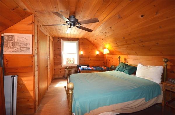 63 Concord Road Wayland, MA 01778 - Photo 18 of 30 a bedroom with a bed and a chandelier