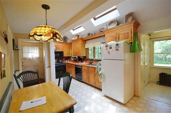 63 Concord Road Wayland, MA 01778 - Photo 4 of 30 a kitchen with refrigerator a stove a chimney a dining table and chairs