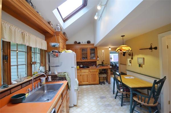 63 Concord Road Wayland, MA 01778 - Photo 5 of 30 a kitchen with a sink a stove and chairs with wooden floor