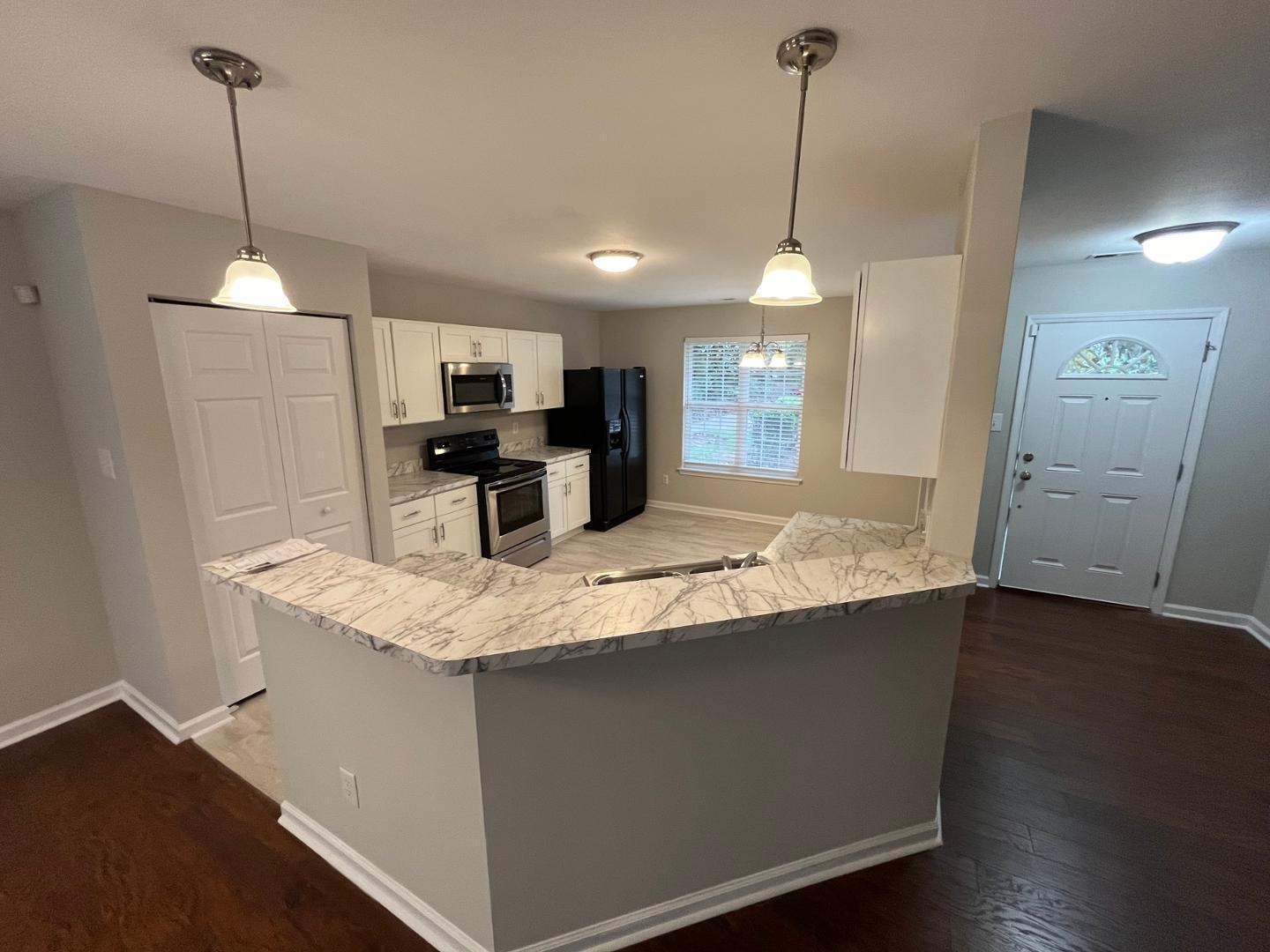 5104 Thornton Knoll Way Raleigh, NC 27616 - Photo 6 of 21 a kitchen with kitchen island a counter top space appliances and a ceiling fan