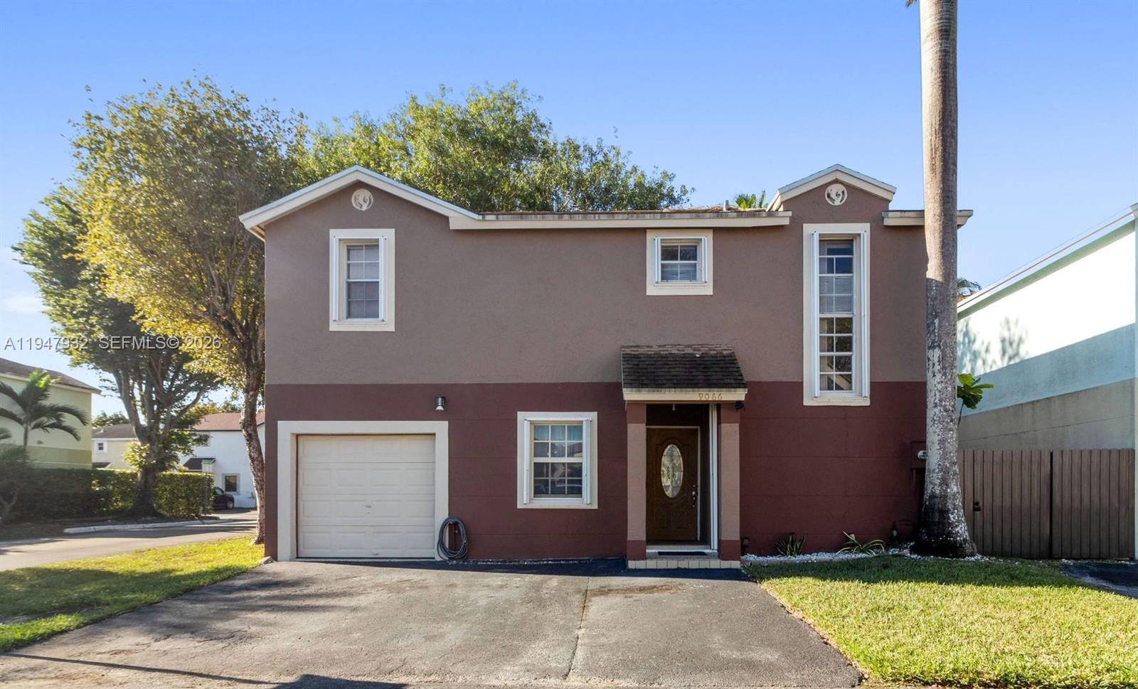 9066 Southwest 147th Court Miami, FL 33196 - Photo 1 of 31 a front view of a house with a garden and yard
