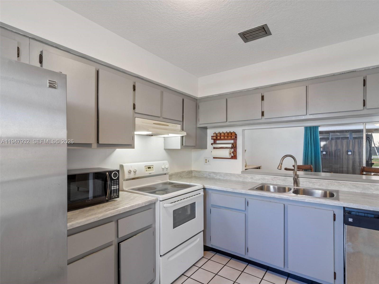 9066 Southwest 147th Court Miami, FL 33196 - Photo 11 of 31 a kitchen with granite countertop a sink stainless steel appliances and cabinets