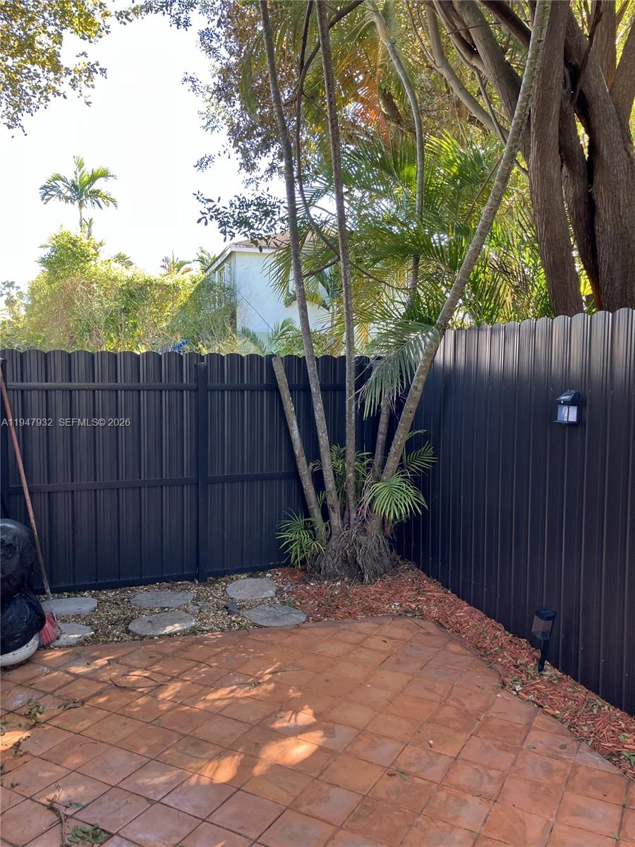 9066 Southwest 147th Court Miami, FL 33196 - Photo 26 of 31 a view of a backyard with plants and wooden fence