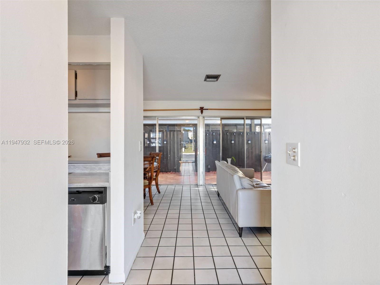 9066 Southwest 147th Court Miami, FL 33196 - Photo 5 of 31 a hallway with a white stove top oven and kitchen island