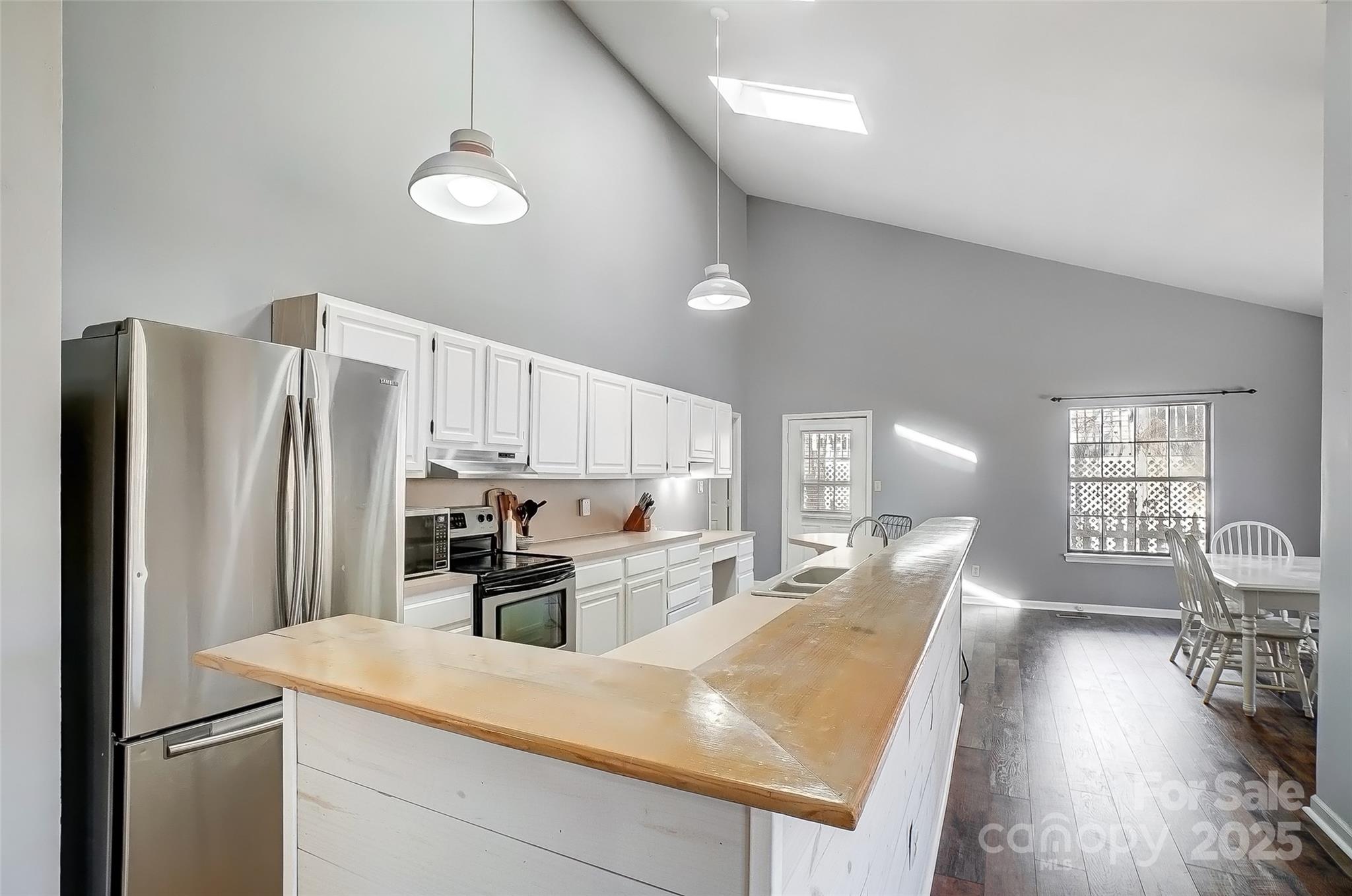 1205 Molokai Drive Tega Cay, SC 29708 - Photo 10 of 33 a kitchen with stainless steel appliances granite countertop a refrigerator a sink dishwasher a stove and white countertops with wooden floor