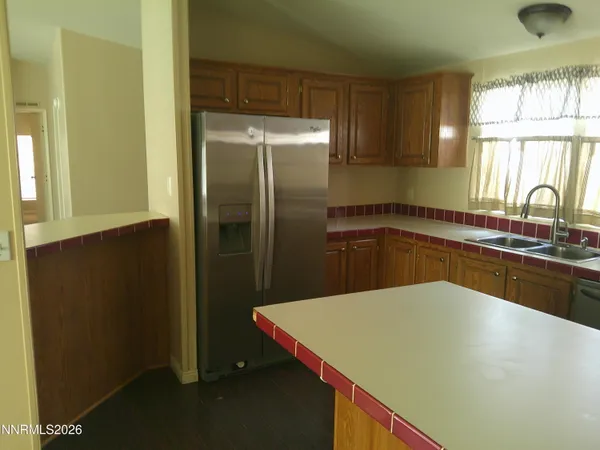 a kitchen with a sink a refrigerator and window