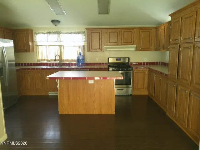 a kitchen with stainless steel appliances granite countertop a stove a sink and a refrigerator