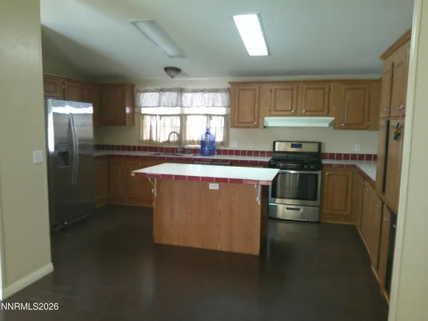 a kitchen with stainless steel appliances granite countertop a stove a sink a refrigerator and a cabinets