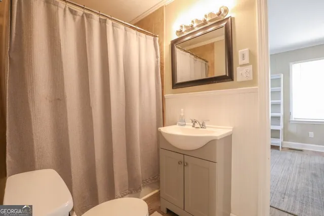 a white toilet sitting next to a bathroom sink and a shower