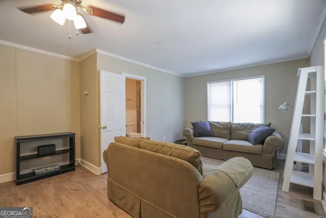 a living room with furniture a ceiling fan and a wooden floor
