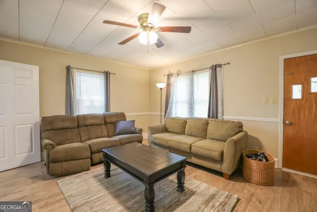 a living room with furniture and a wooden floor
