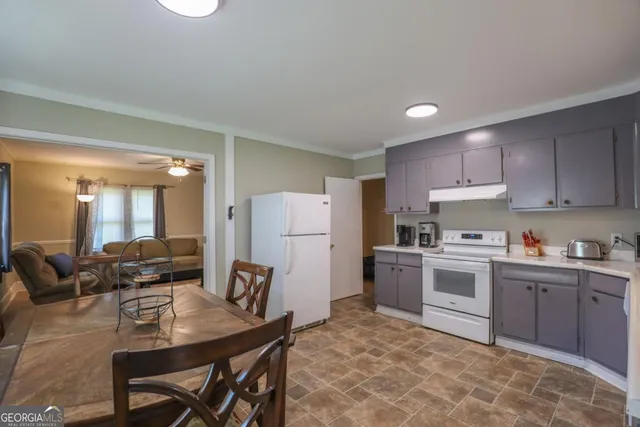 a kitchen with a refrigerator and a stove top oven