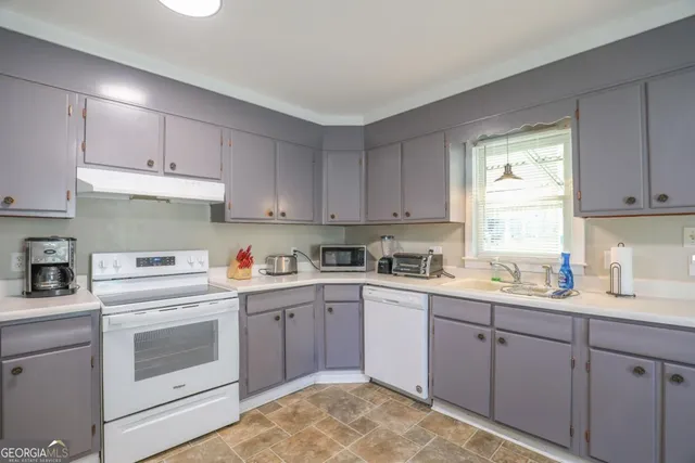 a kitchen with a sink a stove and cabinets