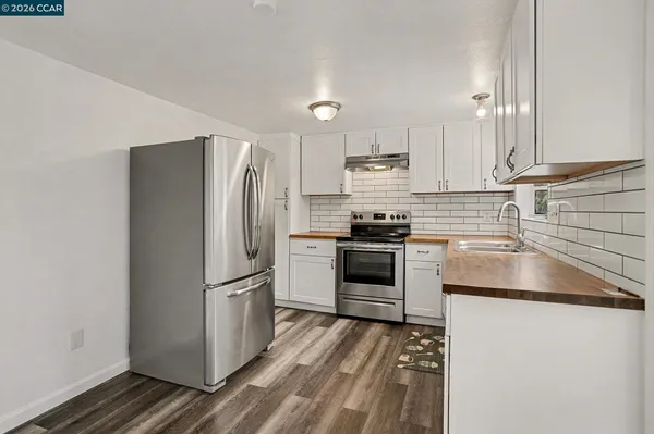 a kitchen with a refrigerator stove and white cabinets