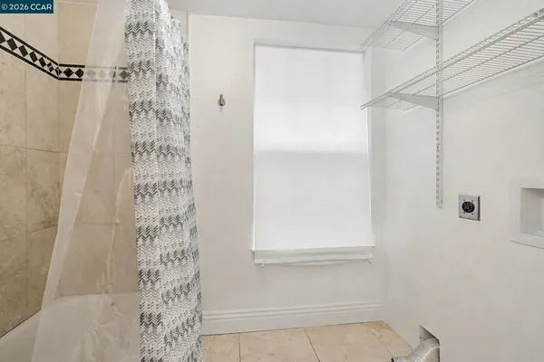 a bathroom with a shower curtain and a window