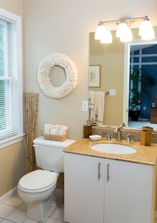 335 Bishops Forest Drive, Unit 335 Waltham, MA 02452 - Photo 17 of 21 a bathroom with a granite countertop toilet sink and mirror