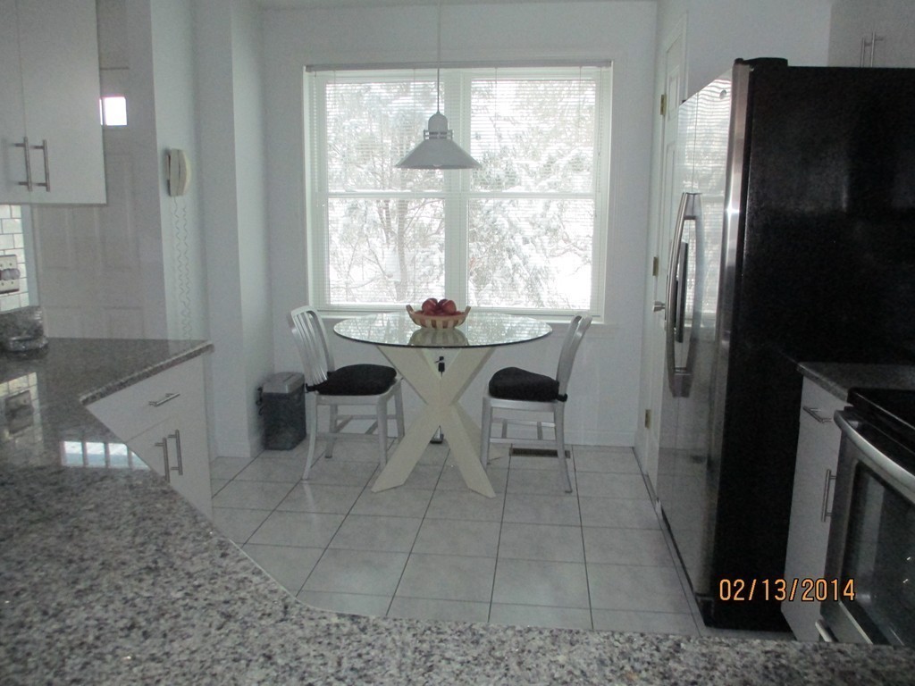 335 Bishops Forest Drive, Unit 335 Waltham, MA 02452 - Photo 3 of 21 a view of a kitchen with a sink and refrigerator