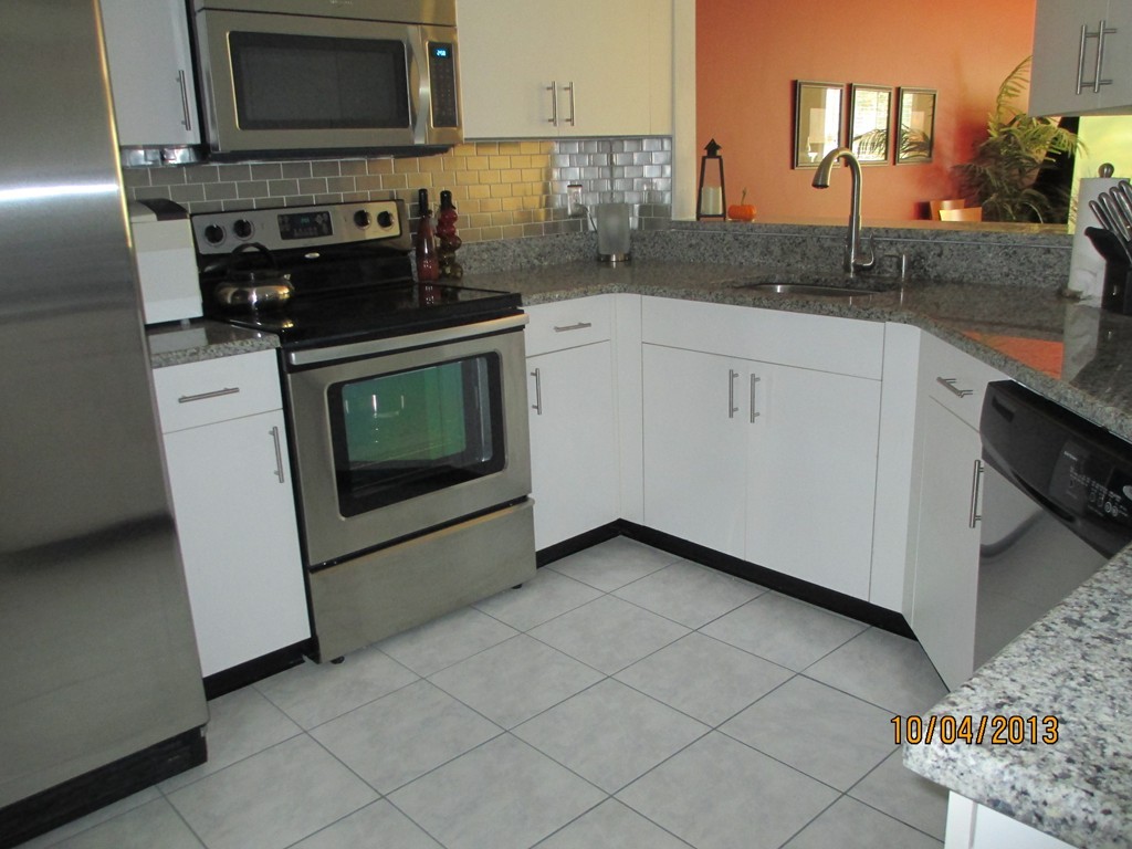 335 Bishops Forest Drive, Unit 335 Waltham, MA 02452 - Photo 4 of 21 a kitchen with stainless steel appliances granite countertop a stove a sink and a microwave