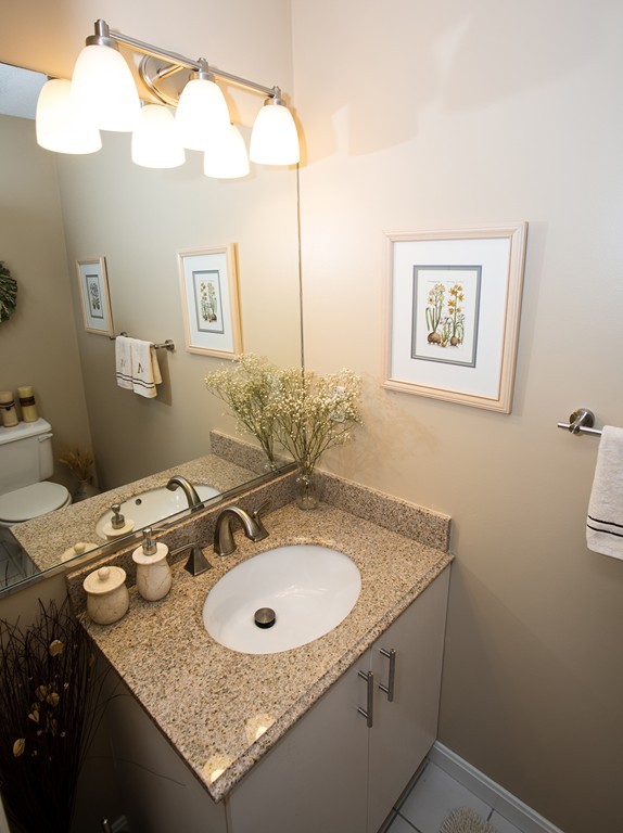 335 Bishops Forest Drive, Unit 335 Waltham, MA 02452 - Photo 5 of 21 a bathroom with a sink and a mirror