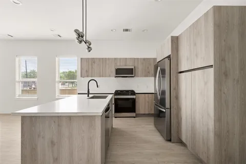 a kitchen with stainless steel appliances a refrigerator sink and white cabinets