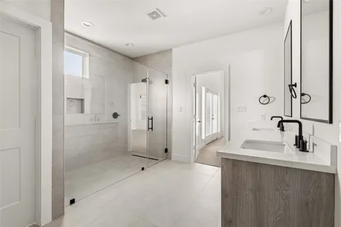 a bathroom with a shower sink and mirror