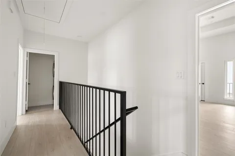 a view of a hallway with wooden floor and entryway